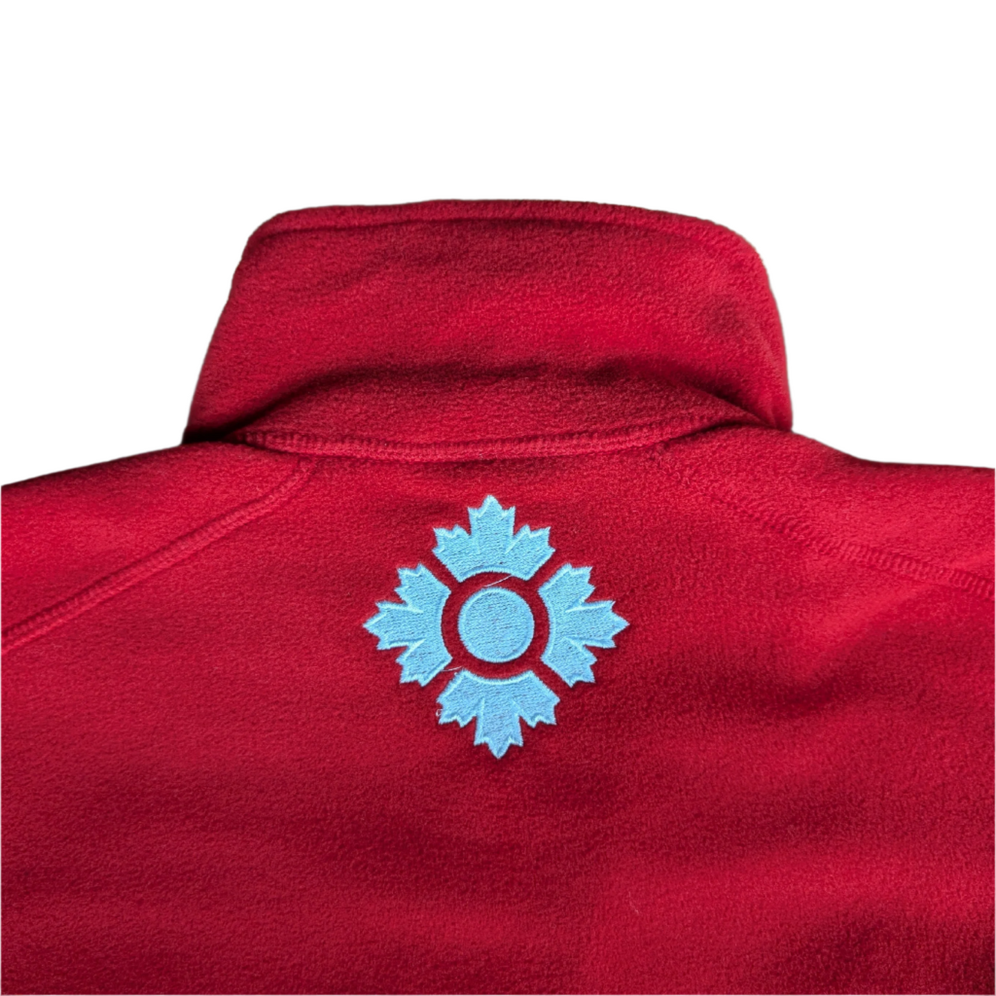 Close up of white logo on the back of the red zip up fleece 