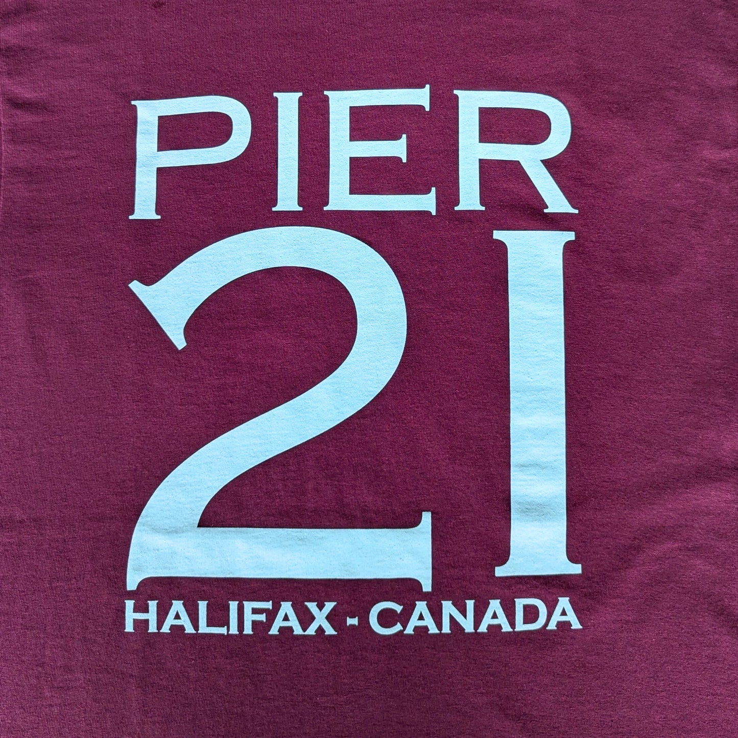 Close up of Pier 21 Halifax Canada on burgundy t-shirt 