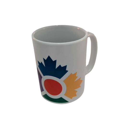 Tall, white mug with colourful icon of four maple leaves in blue, yellow, green and purple with a red circle in the middle 