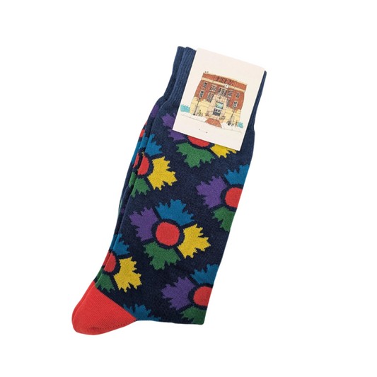 Pair of navy socks with colourful Museum icon in an argyle pattern with a red heel, folded in half lengthways and secured with a Museum branded tag at the top 