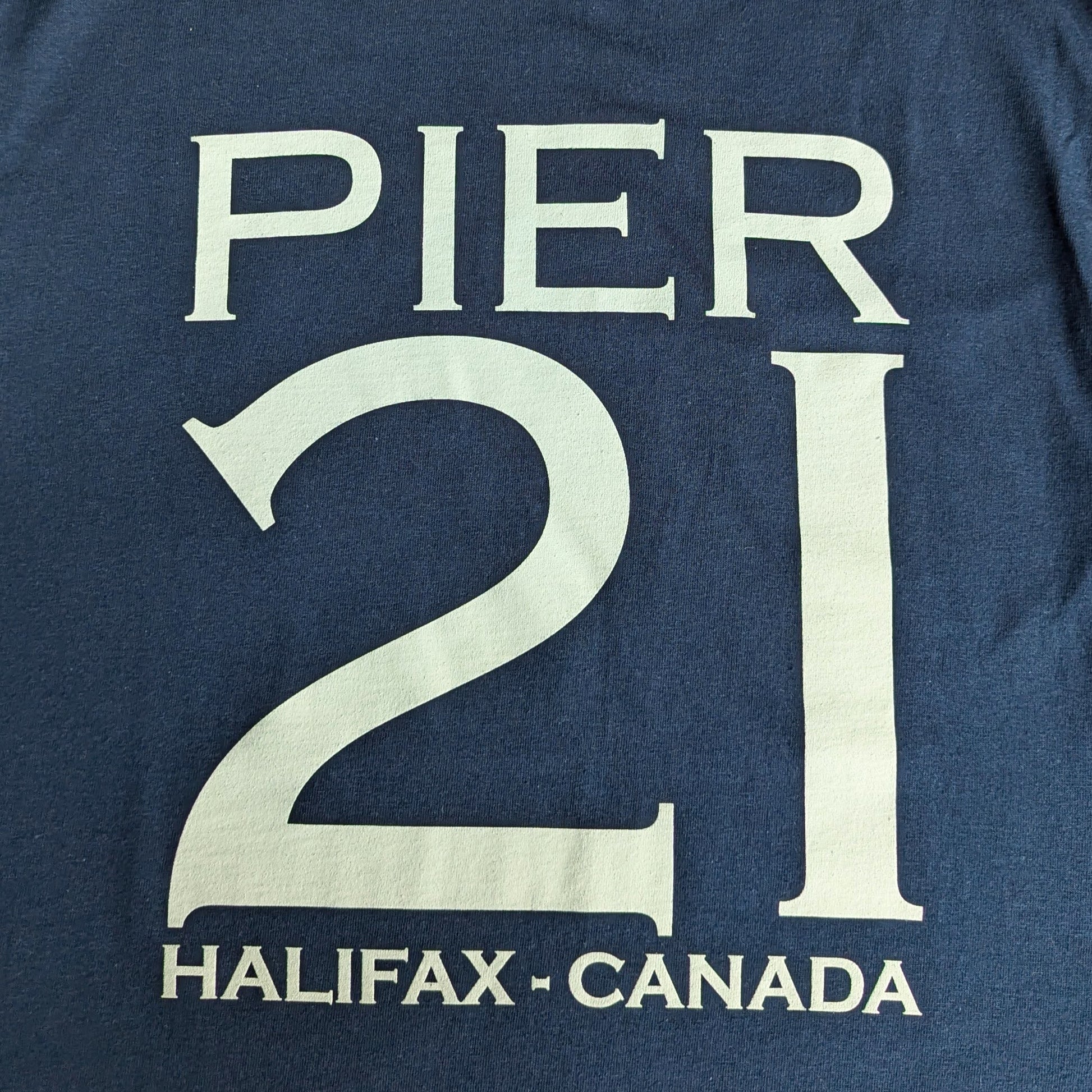 Close up of white Pier 21 Halifax Canada on navy t-shirt