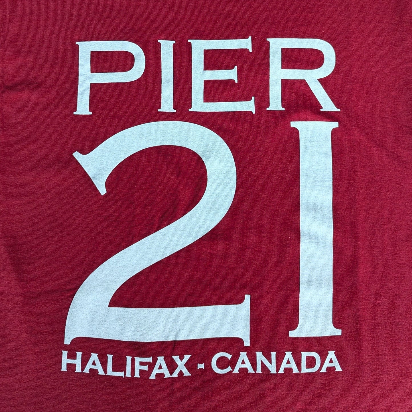 Close up of white Pier 21 Halifax Canada on red t-shirt 